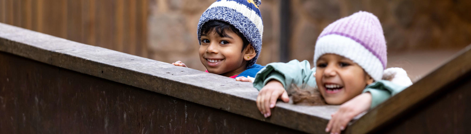 Two excited children looking over the fence to see Tree Kangaroos.