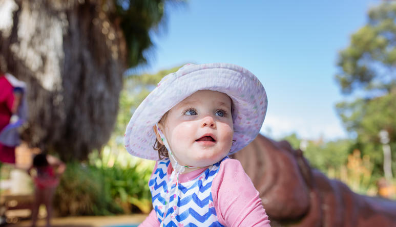 Close-up of young guest at Hippo Beach, wearing a sunhat and looking right of frame.