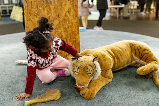 A young guest pets the "Tiger" of Keeper Kids.