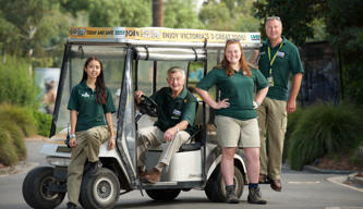 Four volunteers stand proudly with their buggy at Melbourne Zoo.