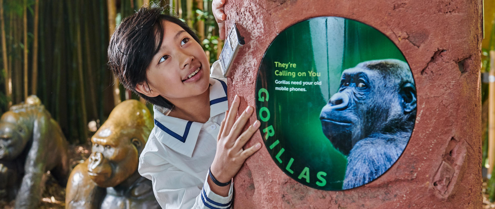 Young guest grabbing a totem pillar featuring a "They're Calling On You" graphic sign.