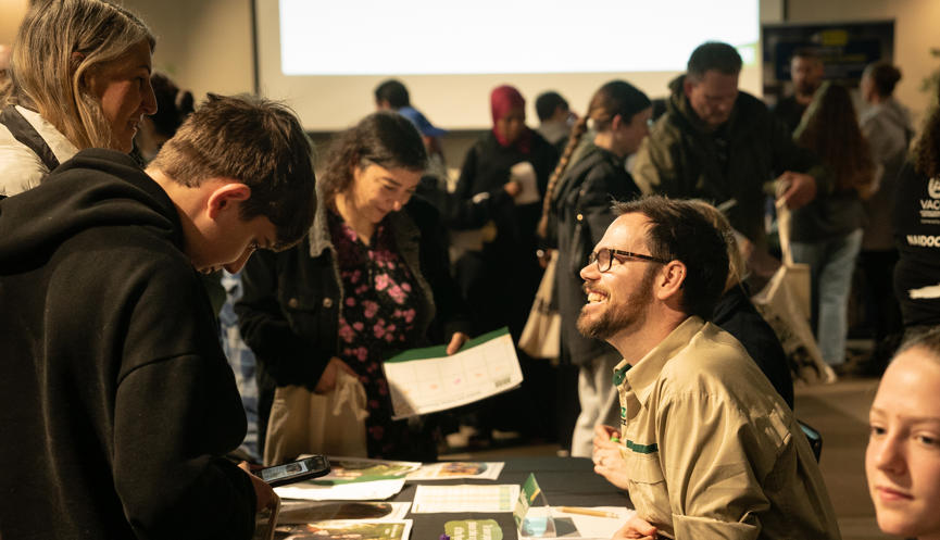 View of a Zoo careers conference in the Leopard Lodge, with a Keeper engaging with visitors.