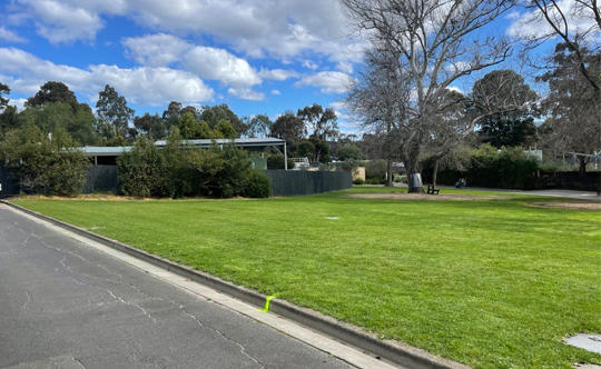 A view of the lawn behind the Melbourne Zoo Reptile House, on an overcast day.