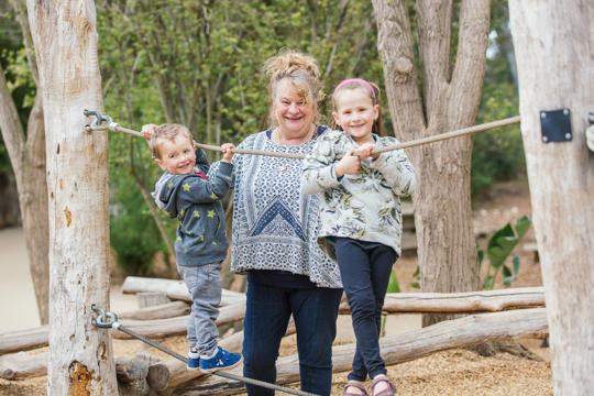 Family of grandparents or seniors playing with grandkids and children on Monkey Rope Play space for Grandparents Week event