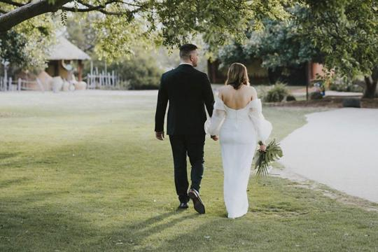 Bride and Groom Walking On Grass