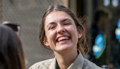A volunteer smiling at the camera, in the company of five others.