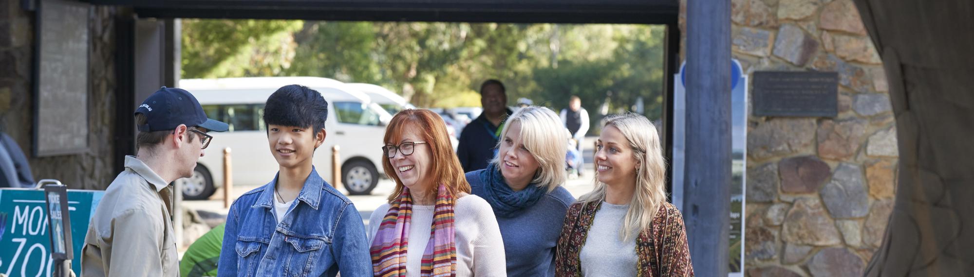 Four guests being greeted by a Keeper at Healesville Sanctuary's Main Entry.