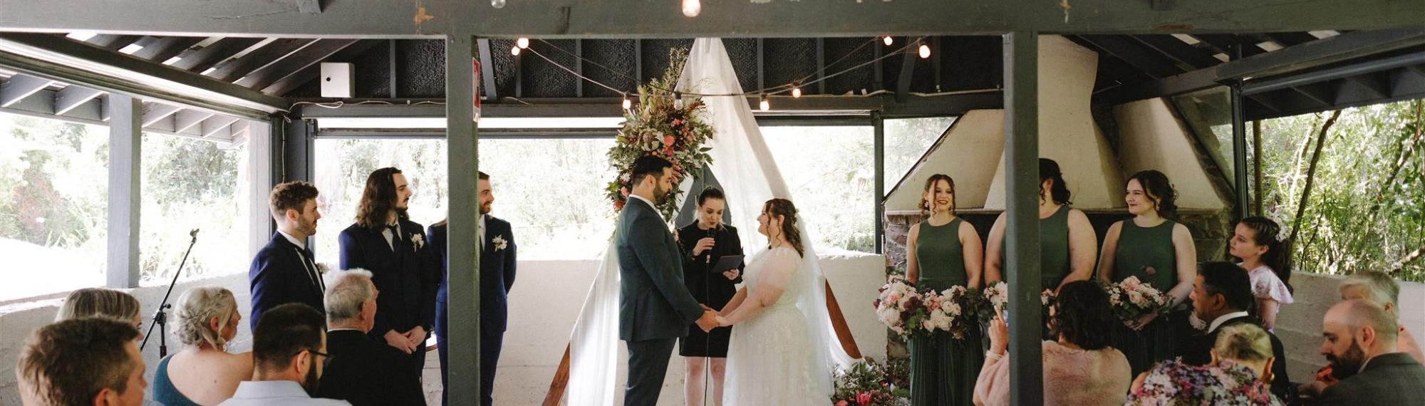 A Wedding Ceremony, taking place in the Robert Eadie Pavilion, with at least twenty guests present.