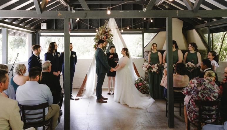 A Wedding Ceremony, taking place in the Robert Eadie Pavilion, with at least twenty guests present.
