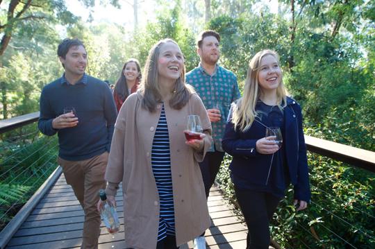 A group of young adults holding Wine & Wildlife glass and walking around the Sanctuary