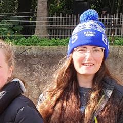 Close-up of two young volunteers holding Elephant browse, smiling to the camera.