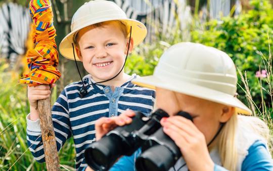 One Kid Looking At Camera Smiling, Another Kid Looking At Binocular