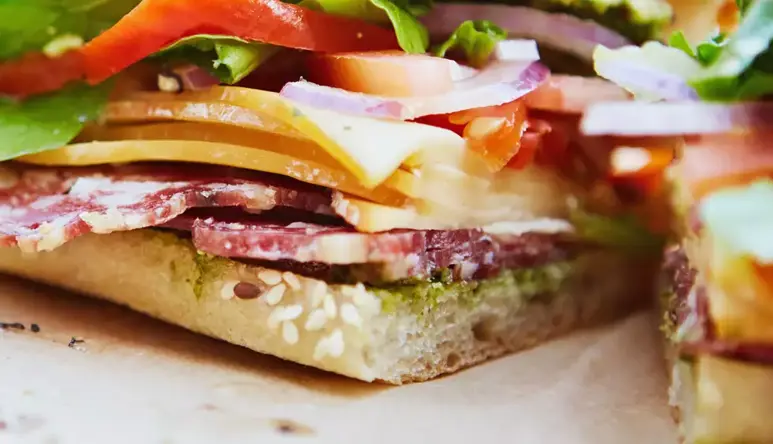 Close-up photo of a focaccia cut in two showing various ingredients.