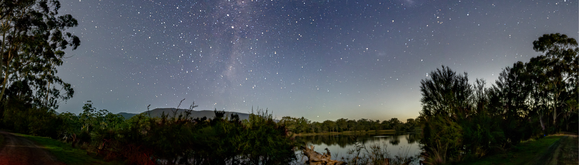 Stars photographed in the Coranderrk for upcoming Sky Country tours; Stitched panorama of Milky Way and stars above lake.