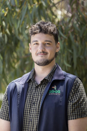 Portrait of Intern Ryan, in front of a leafy backdrop.