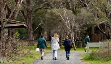 Two guests walking with a Keeper along the trail at Kyabram Fauna Park.