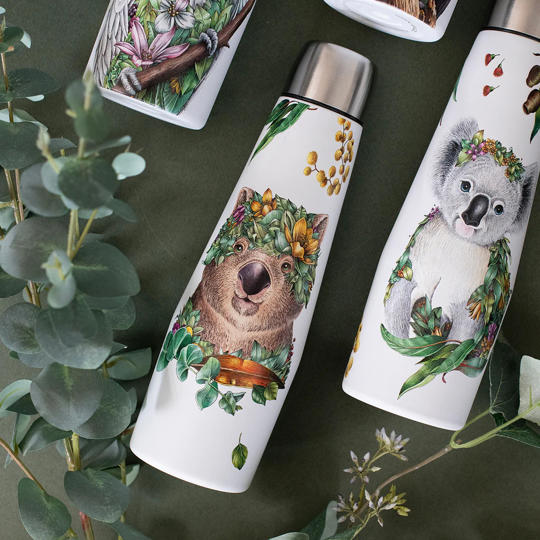Four white metal drink bottles with native marsupials on each one, all lying on a black table-cloth with a branch.