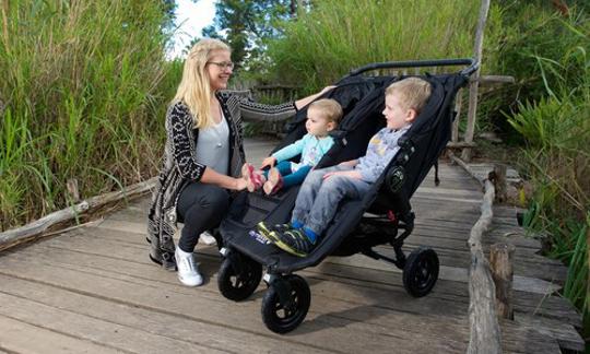 A mum with two kids riding double pram
