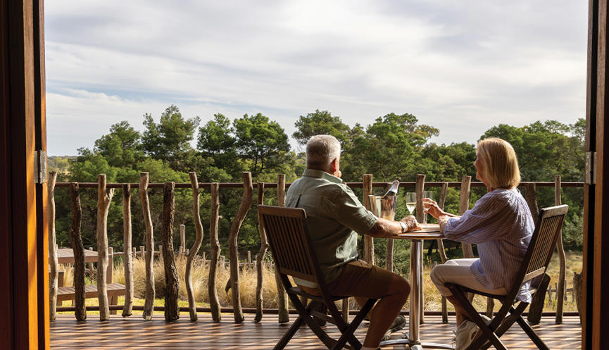 Two guests enjoying wine on a Sunset Safari balcony.