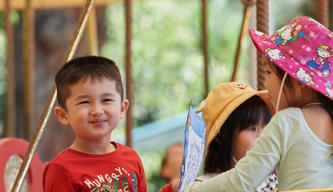 Three young guests riding the Carousel, with one smiling to the camera.