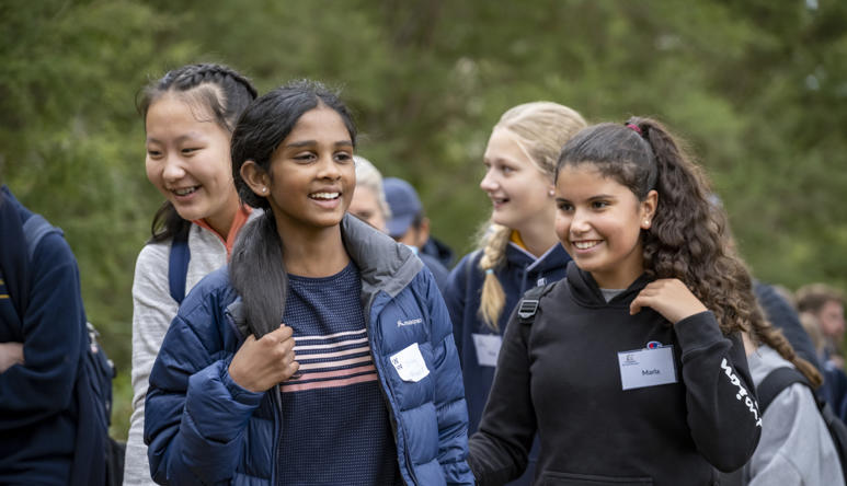 Focus on two visiting students, in a crowd of (at least) ten.