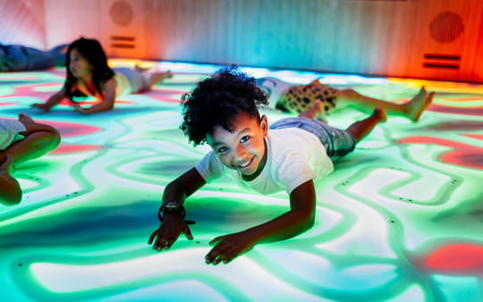 Four young guests "getting down" on the lit-up floor of the Dragon Disco.