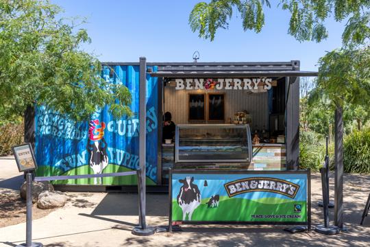 Blue and green shipping container that says Ben & Jerry's displaying ice creams in a freezer