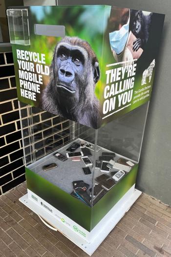 A large glass box full of old mobile phones, with the label "Recycle your old mobile phones here" and a photo of a gorilla.
