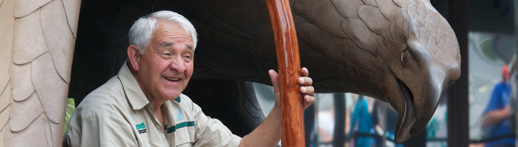 Sitting under the large eagle statue at the front entrance, Murrundindi smiles to visitors, holding a large didgeridoo to teach about Indigenous culture.